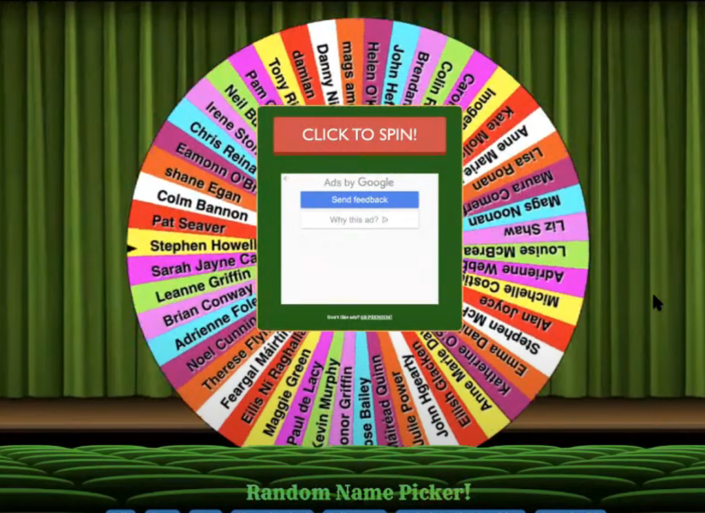 a screenshot of an online random name picker in the shape of an upright roulette wheel, loaded with about 50 name, and the prompt "click to spin" in the centre
