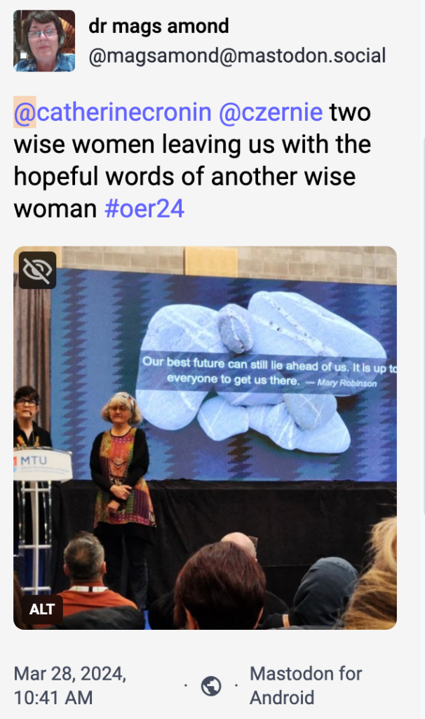 two women called Catherine Cronin and Laura Czerniewicz stand on a stage, in front of a slide that says Our best future can still lie ahead of us. it is up to everyone to get us there, a quote from Mary Robinson